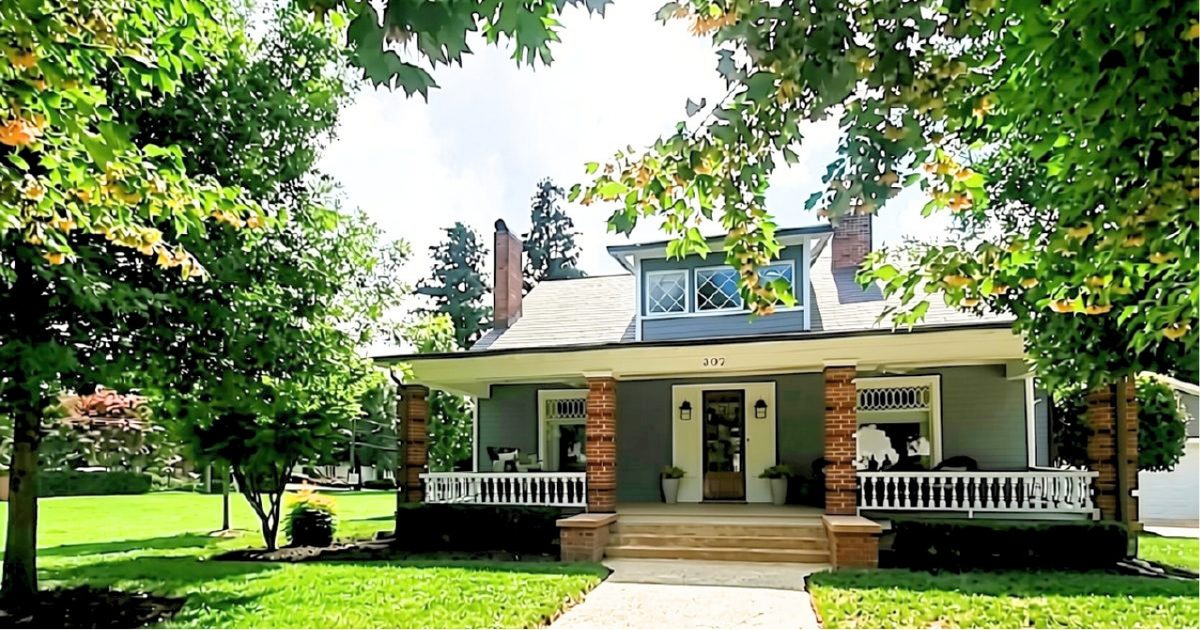 Brick front porch and walkway of a 1918 house at 307 N Main Street in the Belmont NC Historic District, framed by mature trees